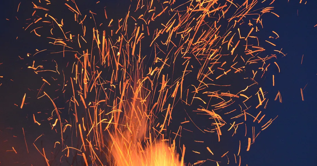 Fire sparks on a night sky represent AI's emergence in clinical care