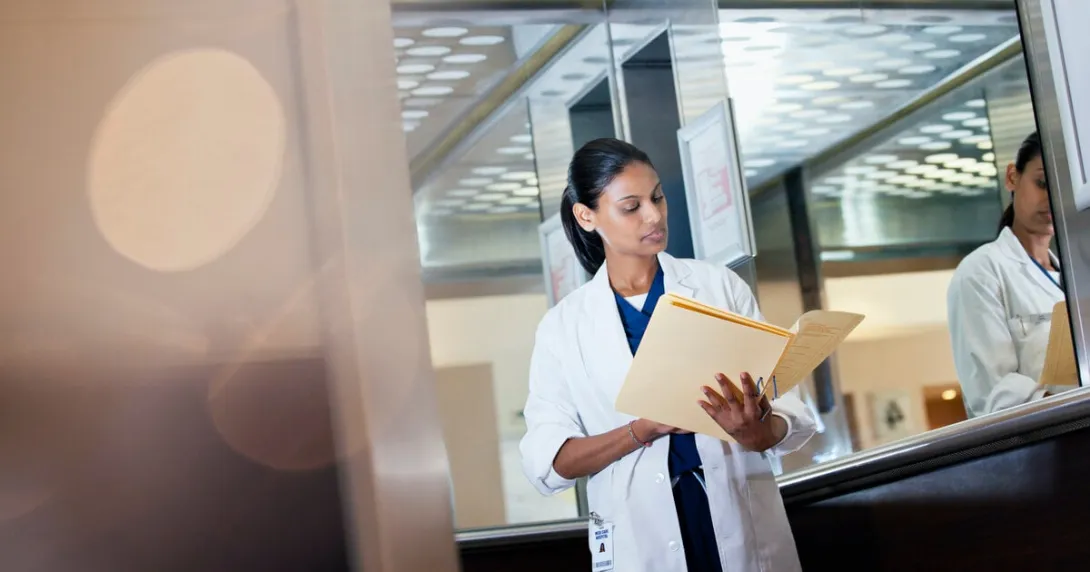 A doctor looking at a patient paper record