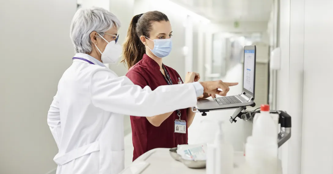 Physician and nurse at computer in hospital