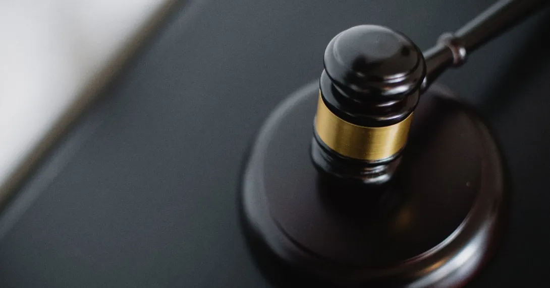 Black and gold gavel on a black table.