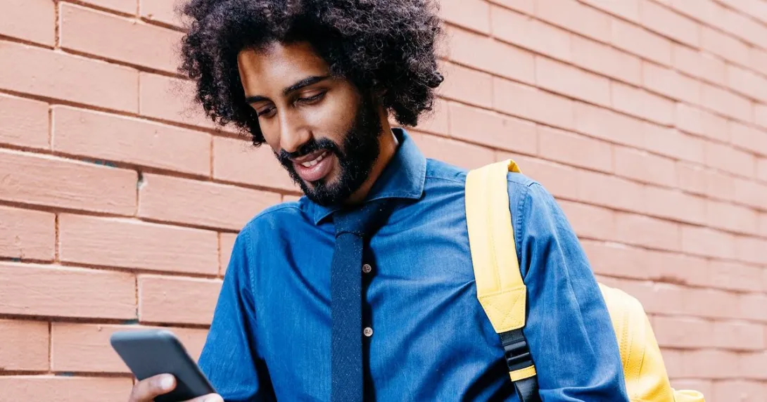 Man with backpack on mobile device