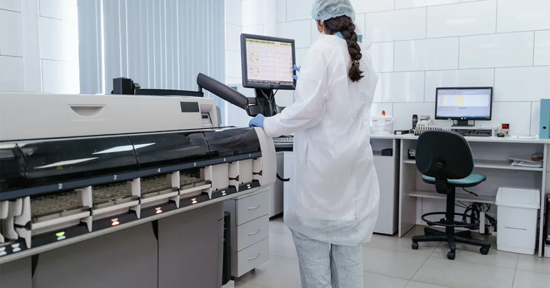 Person in a lab views machine monitor