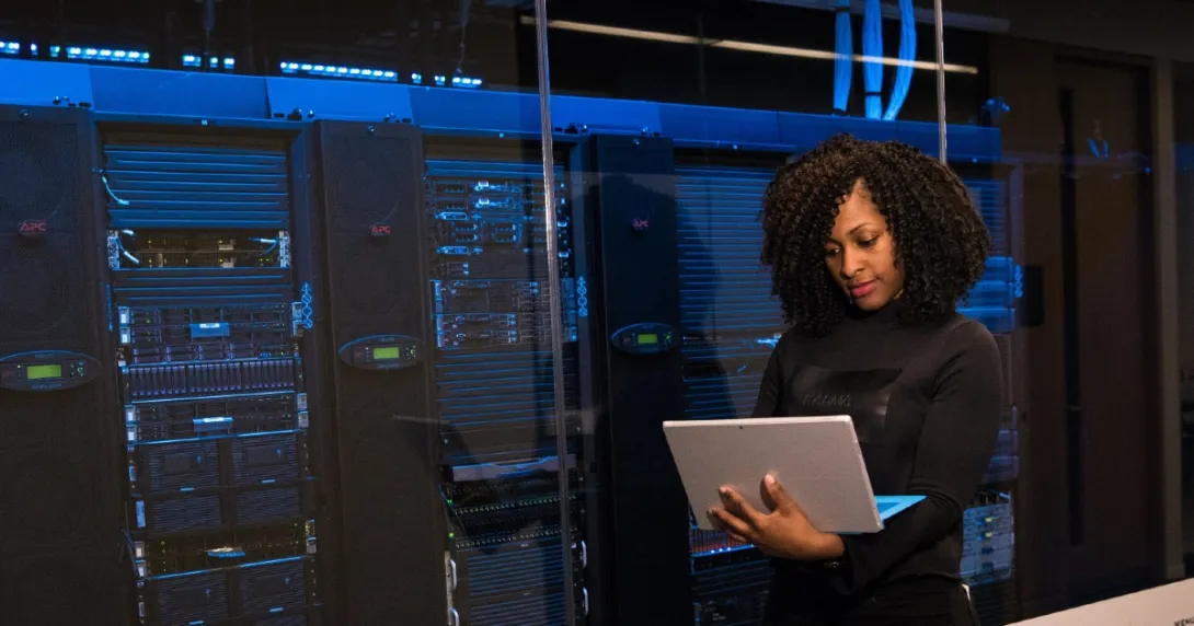 A software engineer standing near a server room