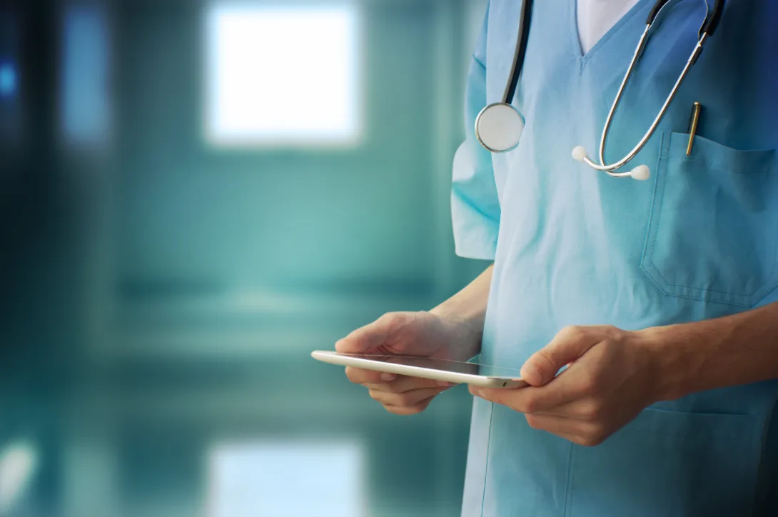 A medical professional using a tablet.
