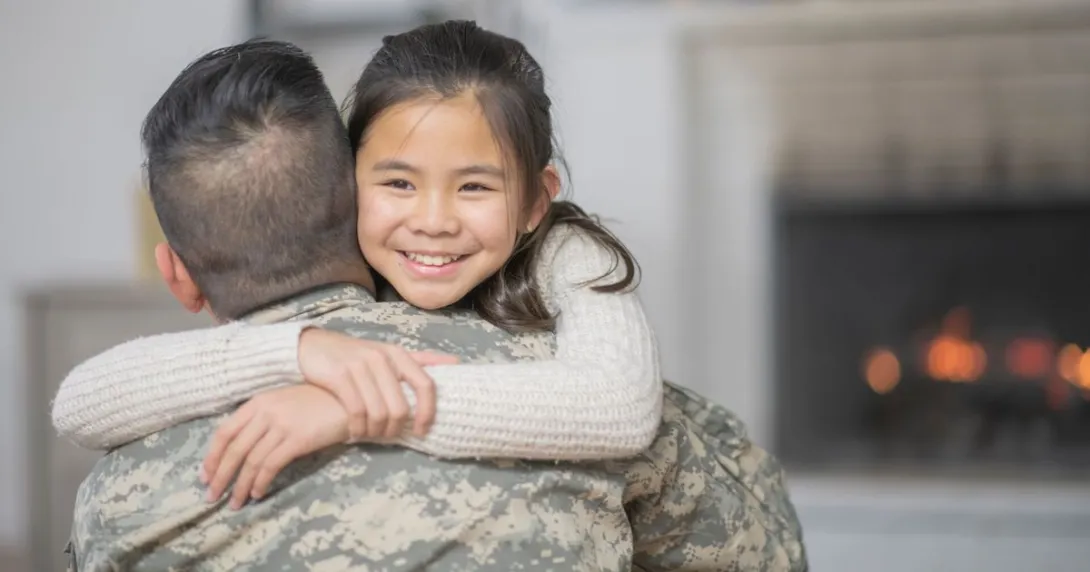 Servicemember hugs child