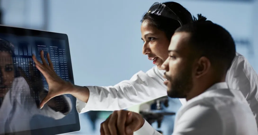 Scientists analysing data shown on a desktop computer