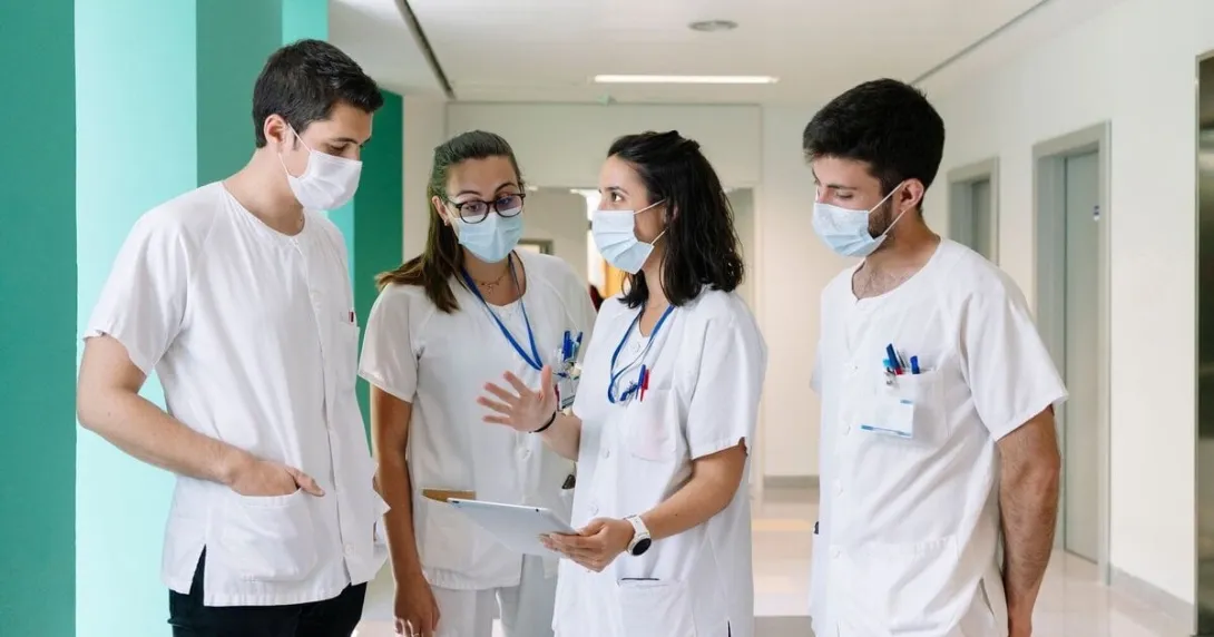 Hospital staff huddled, discussing among themselves