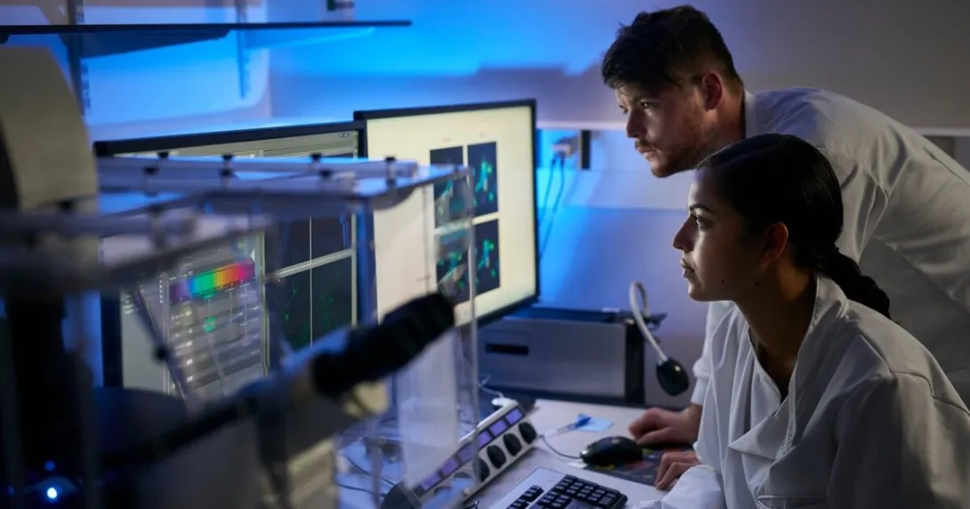 Lab researchers viewing graphs on a desktop computer