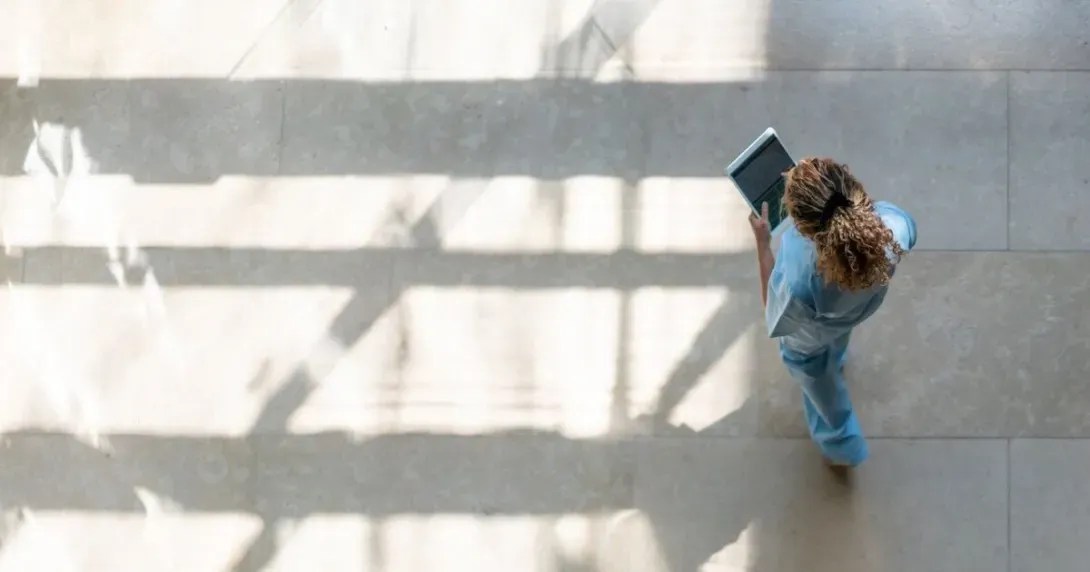 Individual walking uses a tablet to access medical records