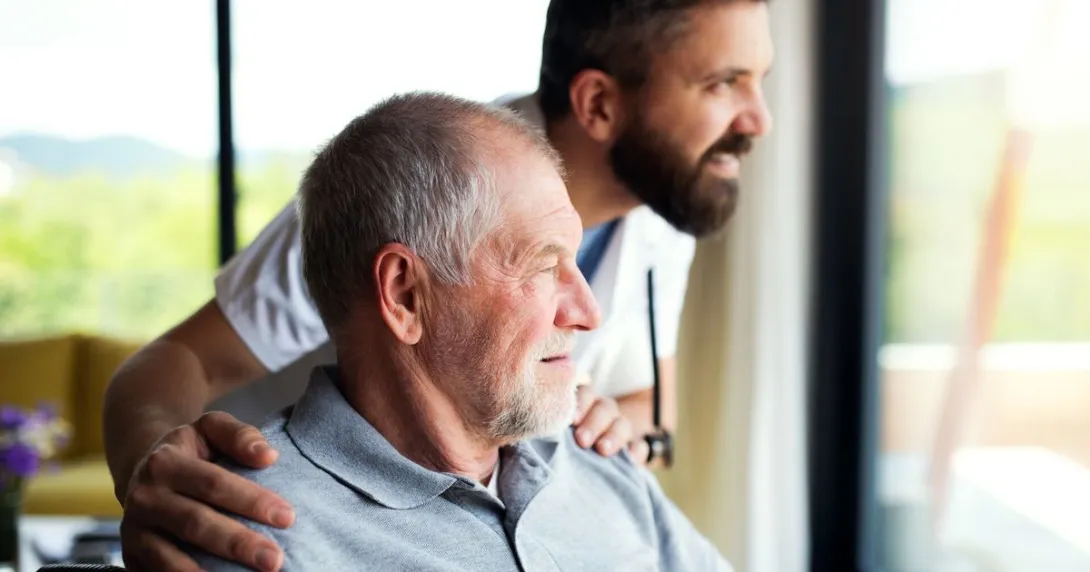 Caregiver and an elderly resident looking out a window