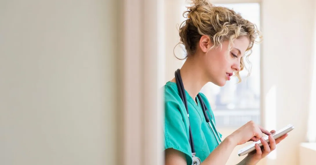 A doctor reading a patient's record on a digital tablet