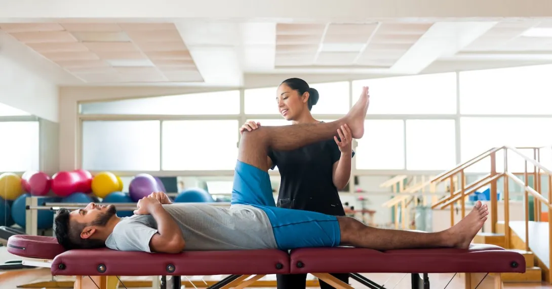 A physical therapist holding up a patient's leg