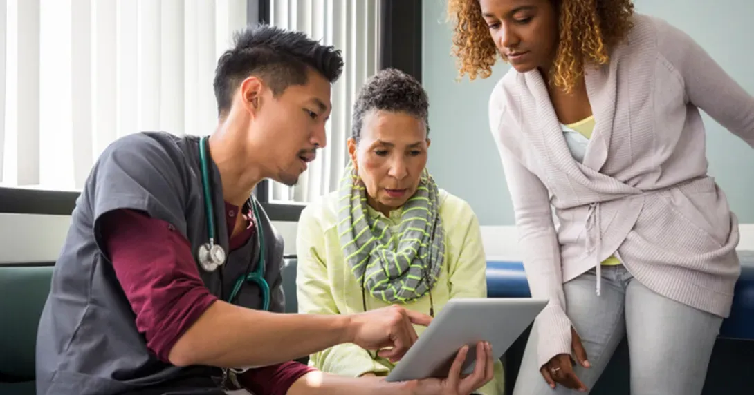 Provider, patient and caregiver look at medical images on a tablet