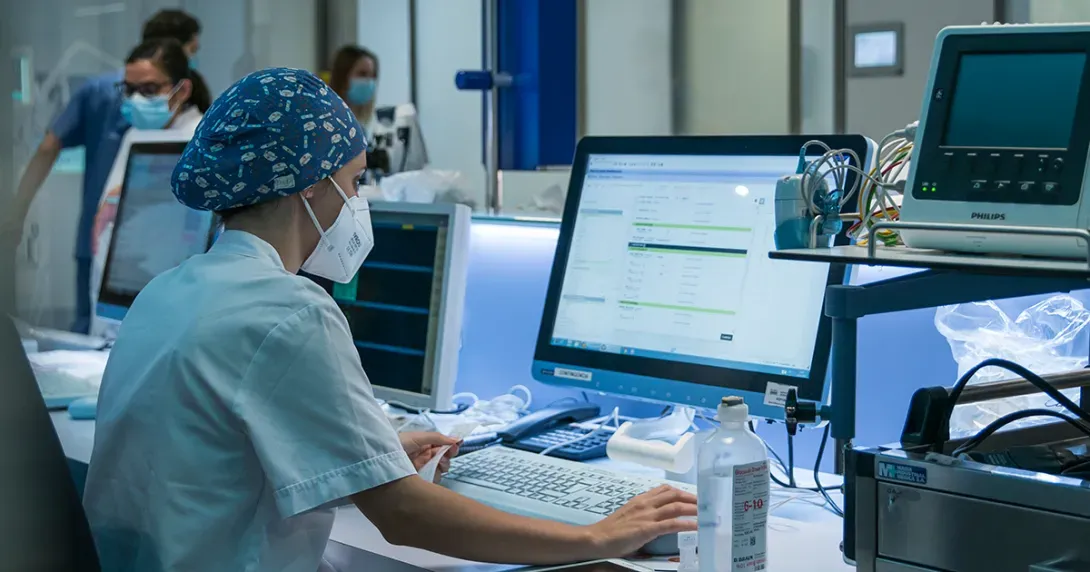 Hospital clinician reviews patient data against printed readout 