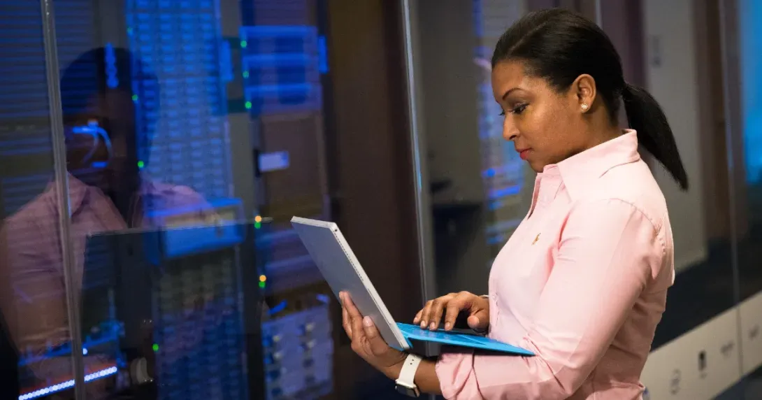 Health IT professional analyzes assets while standing in a server room