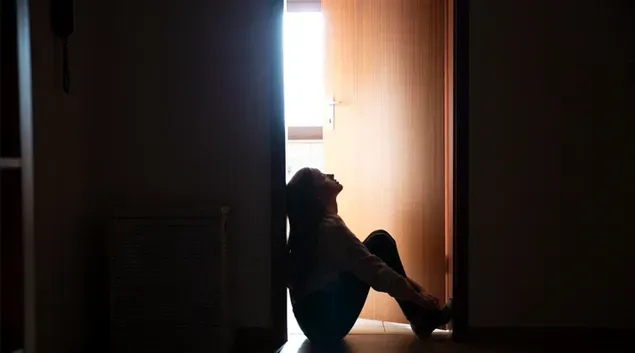 Young woman sits on the floor in a community-based mental health facility