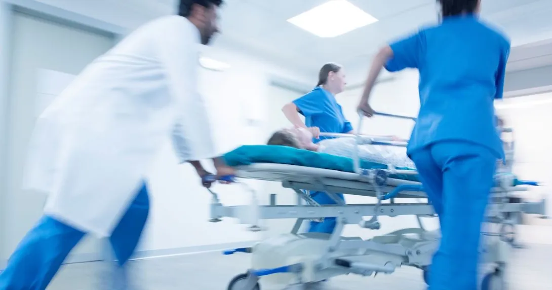 Hospital staff pushing a patient on a gurney