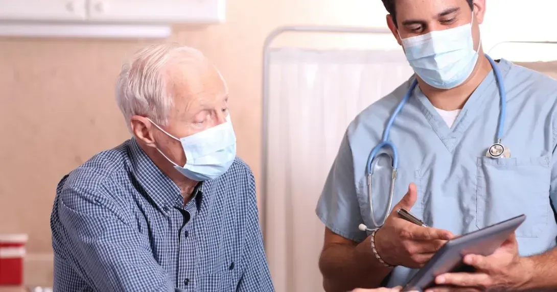 Doctor reviews information with an elderly patient on a tablet