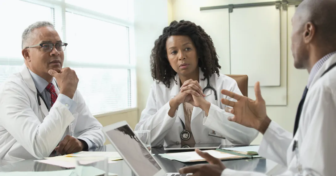 Three clinicians meet at a table