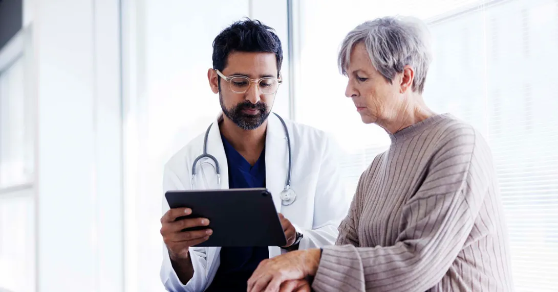 Doctor showing tablet to a patient