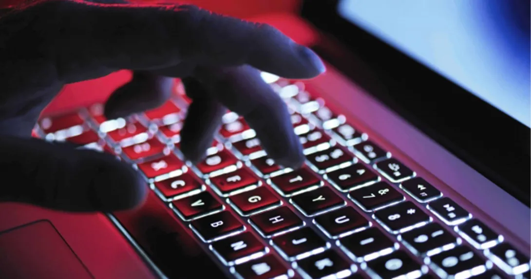 Hand hovers over computer keyboard