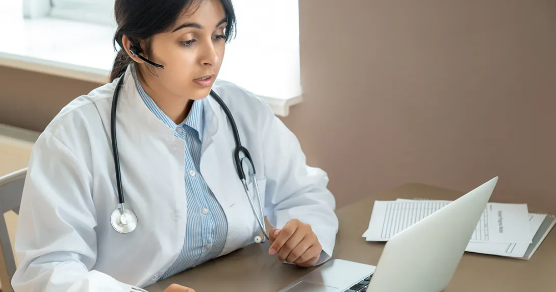 Doctor speaking at laptop