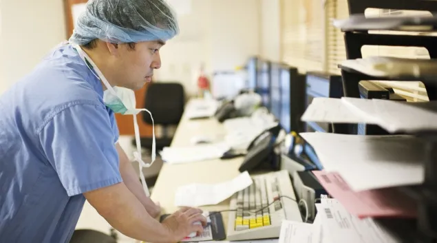Doctor in scrubs using computer
