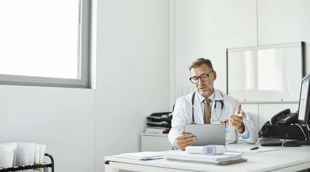 Doctor in an office talk to a tablet