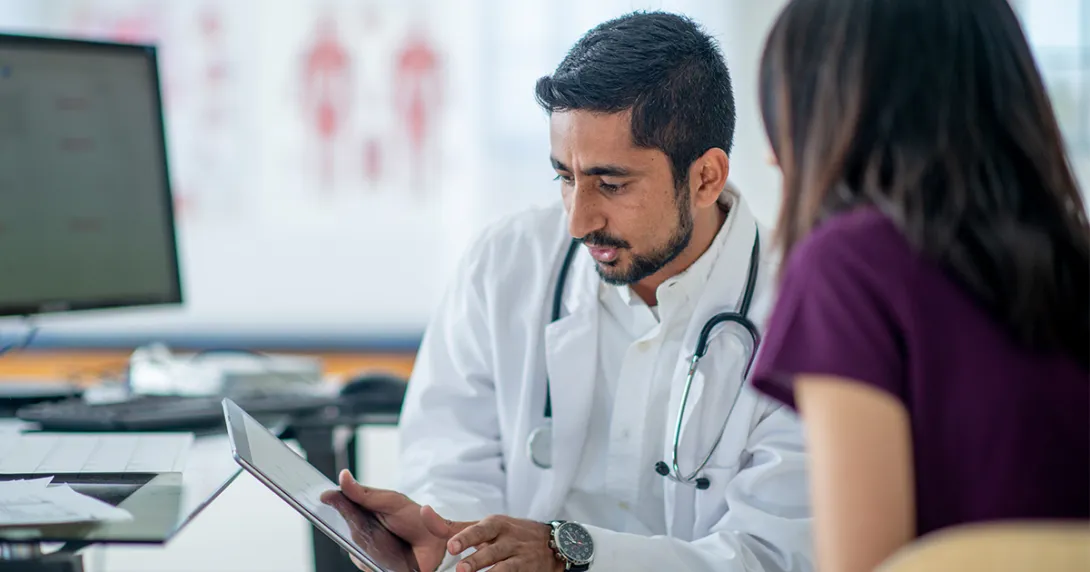 Doctor showing tablet to a patient
