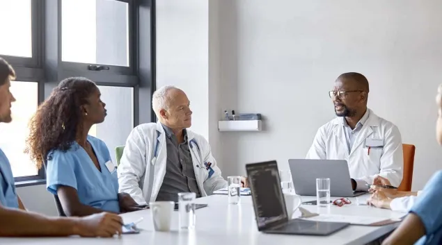 Doctors and other medical workers meeting in a conference room.