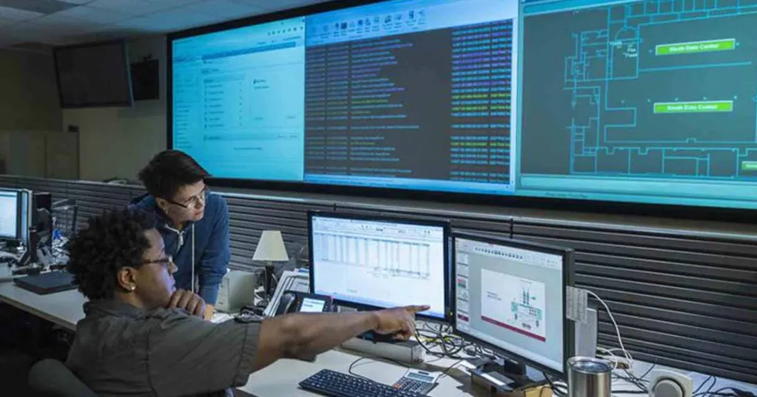 Worker pointing at screen with coworker