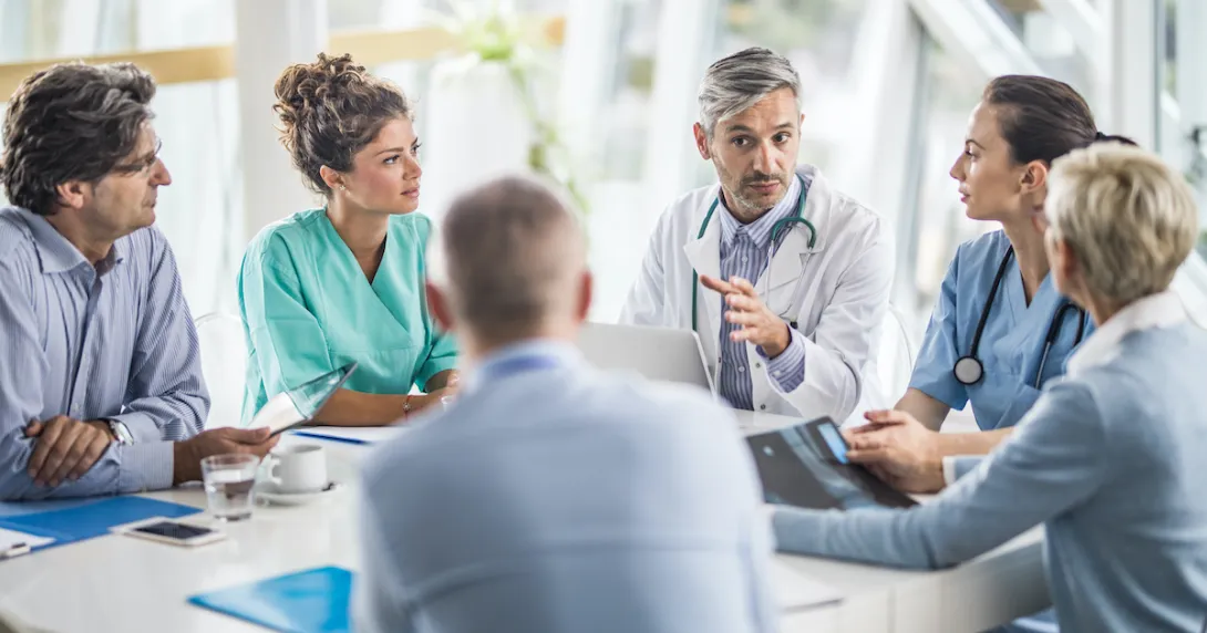 Medical professionals discussing with business people in a hospital meeting