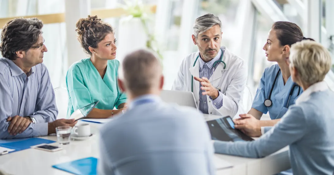 A multidisciplinary team of hospital staff holding a meeting