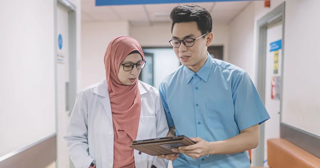Healthcare workers talking and looking at clipboard