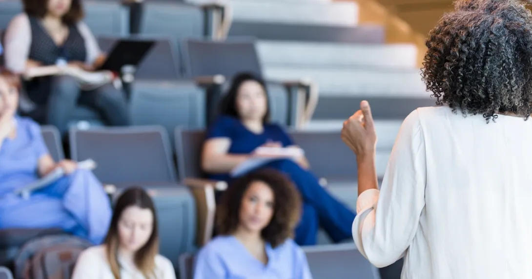 Alt text: A university instructor lecturing college students