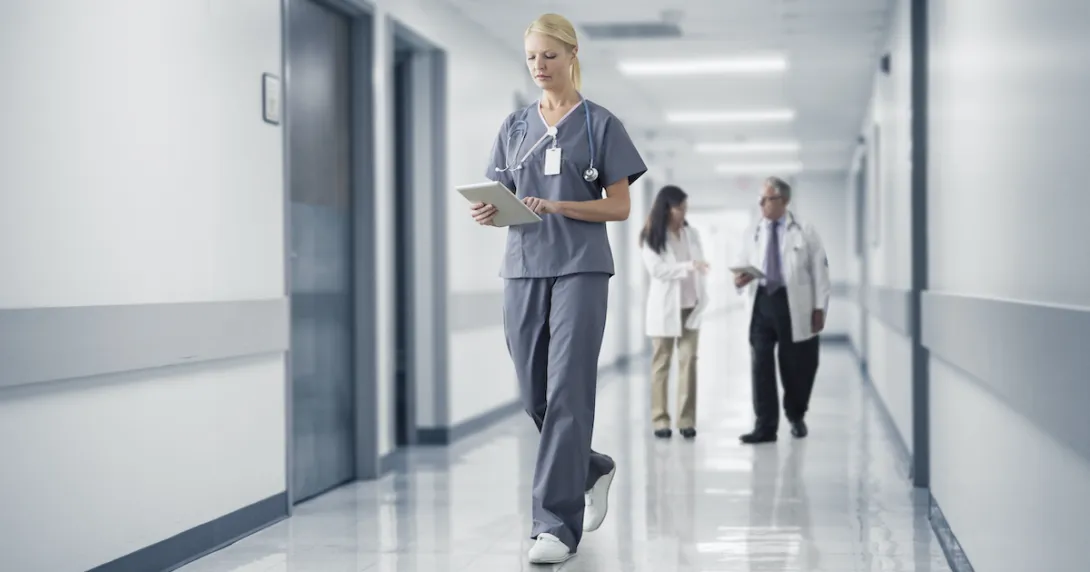 A nurse reading a patient's chart on a digital tablet