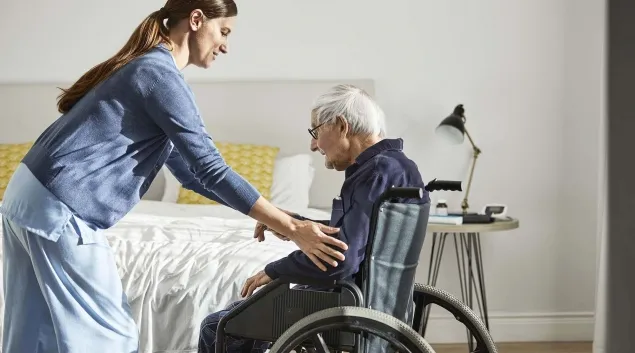 Healthcare worker assisting patient in wheelchair