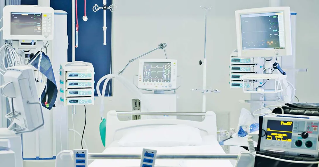 Empty hospital bed with many monitors around