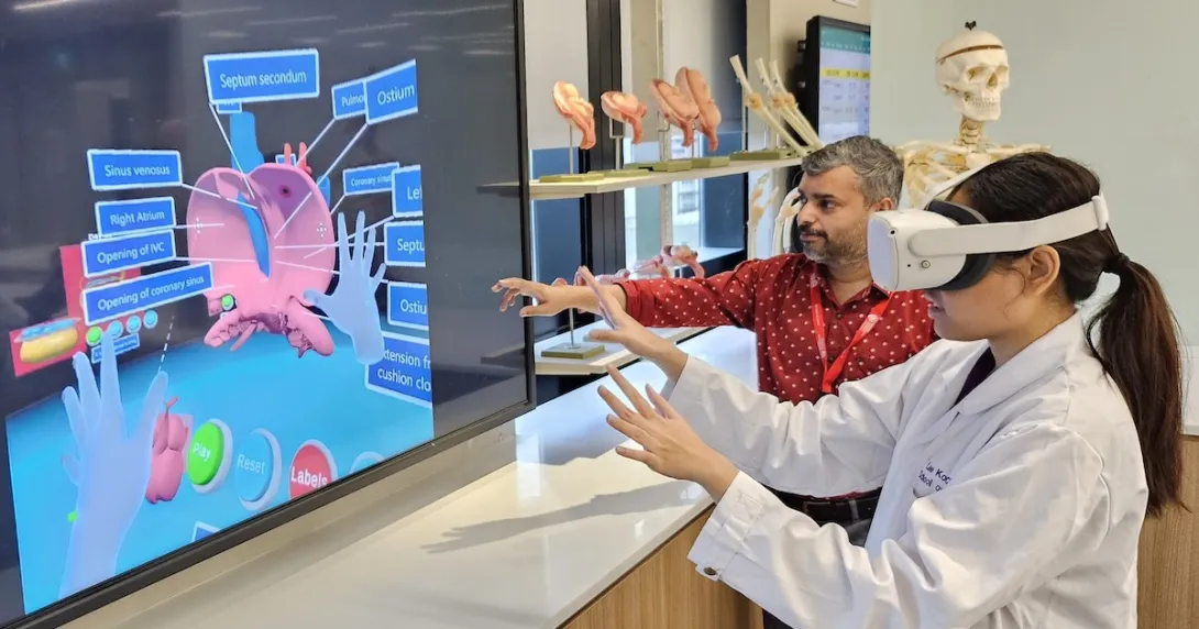A medical student wearing a VR headset is learning the parts of the heart while being assisted by an instructor