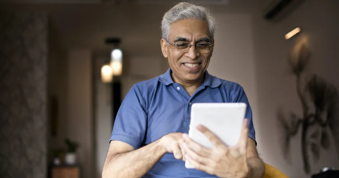 Person smiles as they use an app on a tablet.