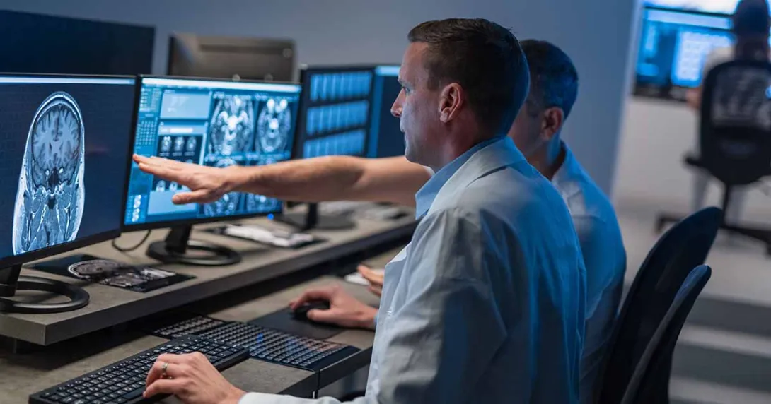 Healthcare workers looking at X-ray on computer monitor