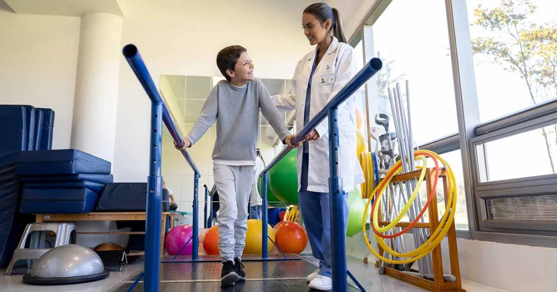 Healthcare worker working with child in physical therapy room