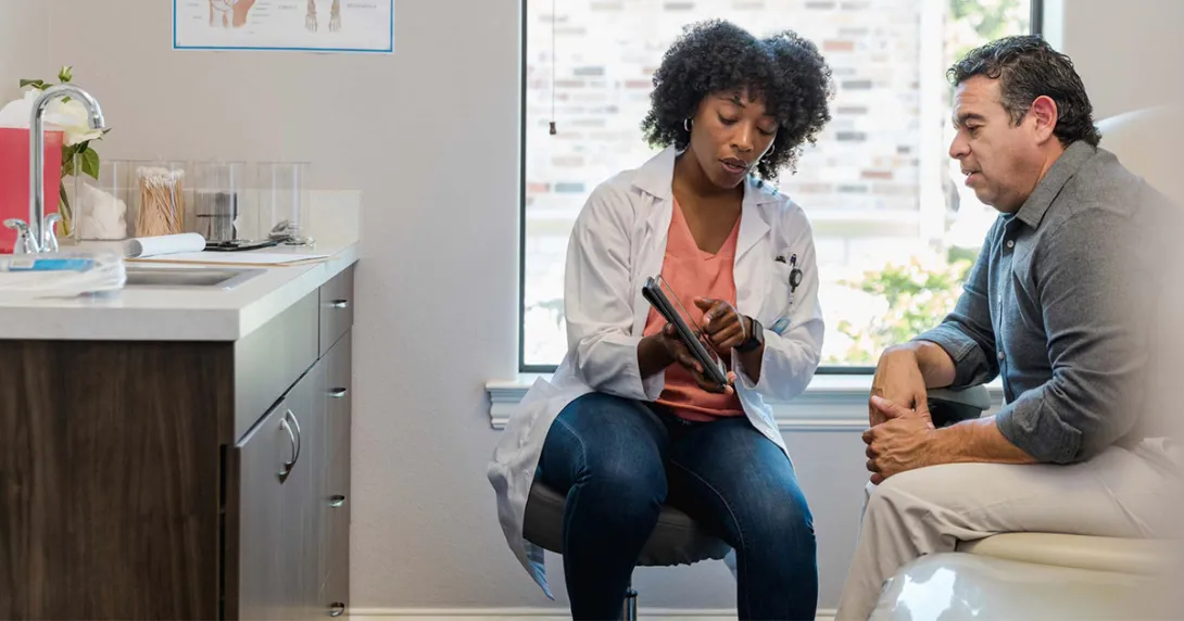 Doctor showing tablet to patient