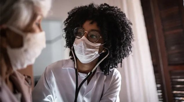 Doctor in mask examining patient in mask