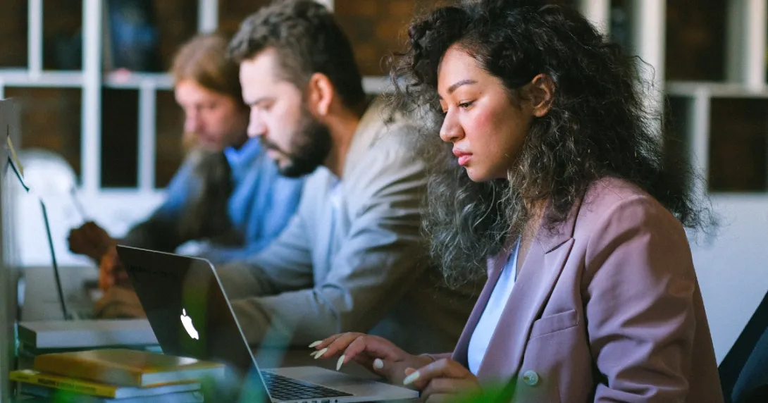 Three people working at laptops