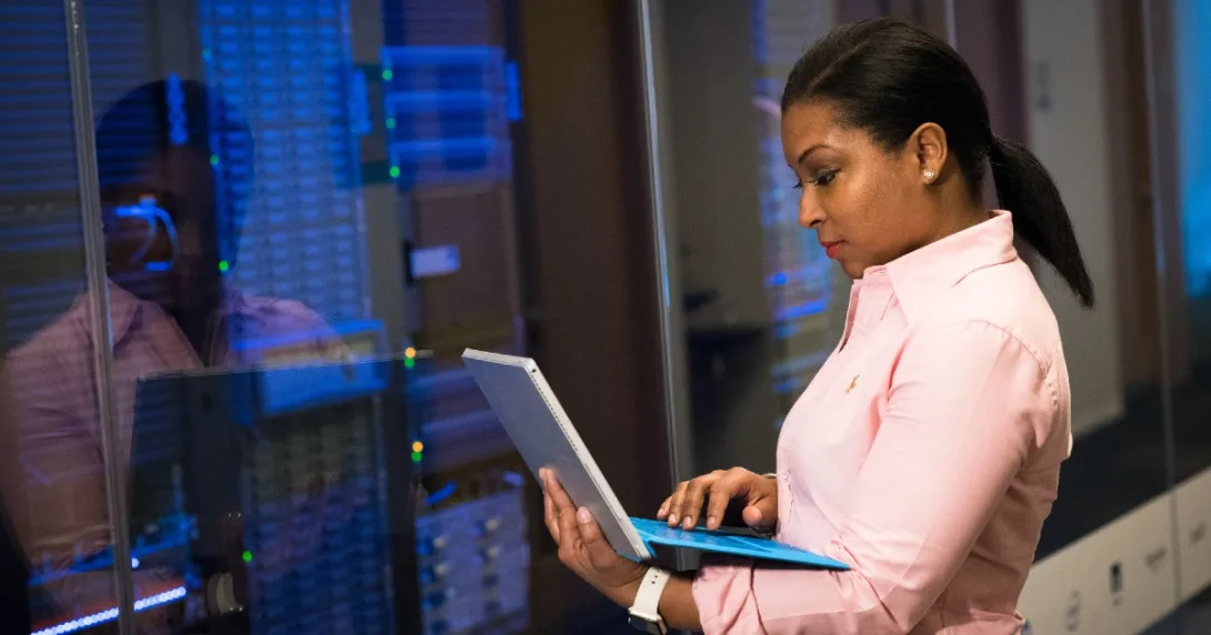Person with laptop in a server room