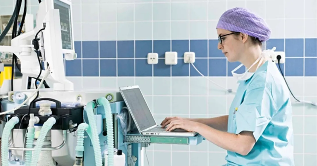 Clinician in scrubs at a hospital computer