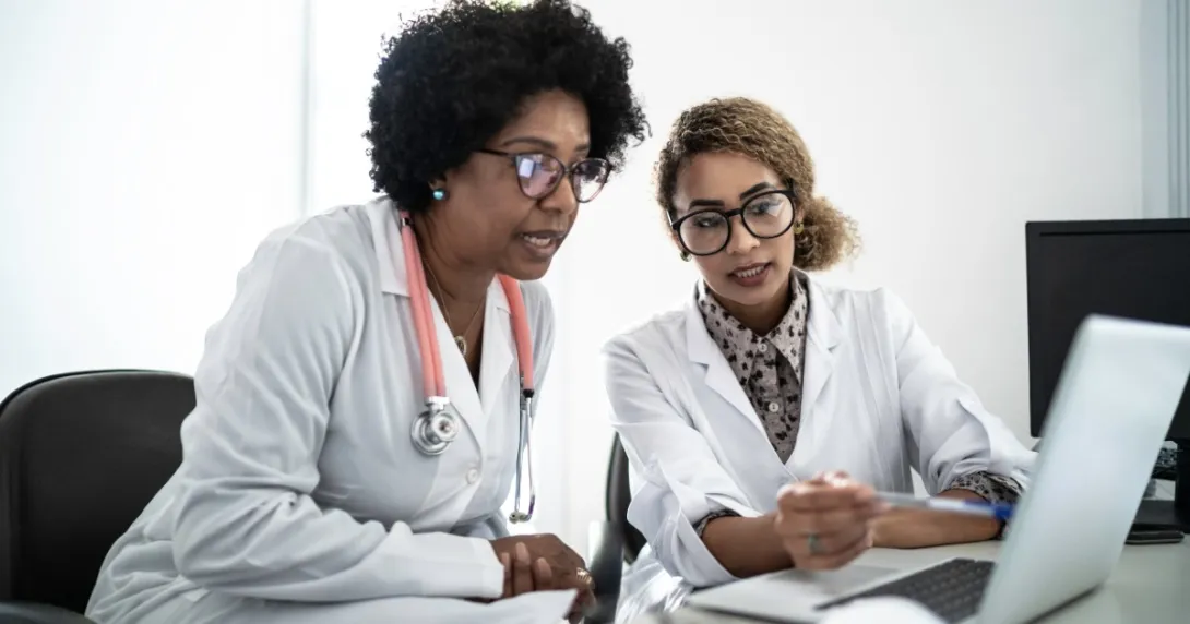 Two health professionals at a laptop