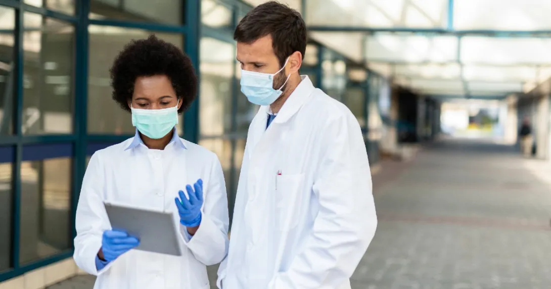 Healthcare professionals in a corridor exmine a tablet