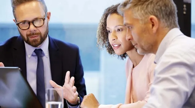 Executives meeting around a laptop